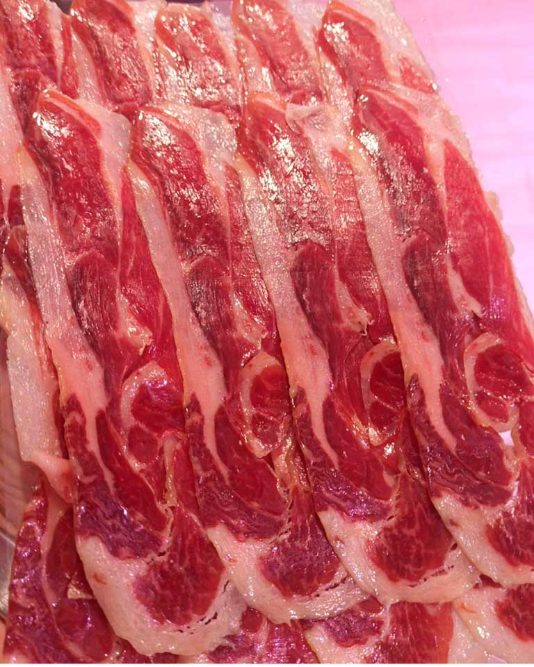 Deliciosas lonchas de paletilla ibérica de bellota, un manjar culinario.