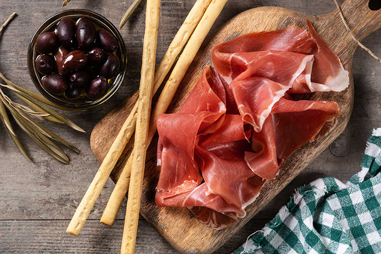 Experto cortando finas lonchas de Jamón Ibérico con un cuchillo jamonero, perfecto para maridajes navideños.